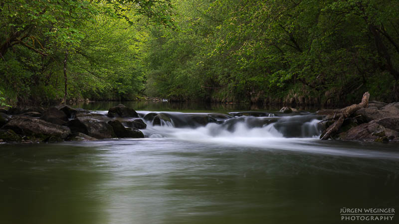 wasserfallfotografie, Langzeitbelichtung, Naturfotografie, Flusslandschaft, düstereslicht, Naturschönheit, dunklestimmung, wasserfallabenteuer, langzeitbelichtungskunst, flussidylle, wasserfallmagie, naturliebe, wasserfallerkundung, dramatischenatur