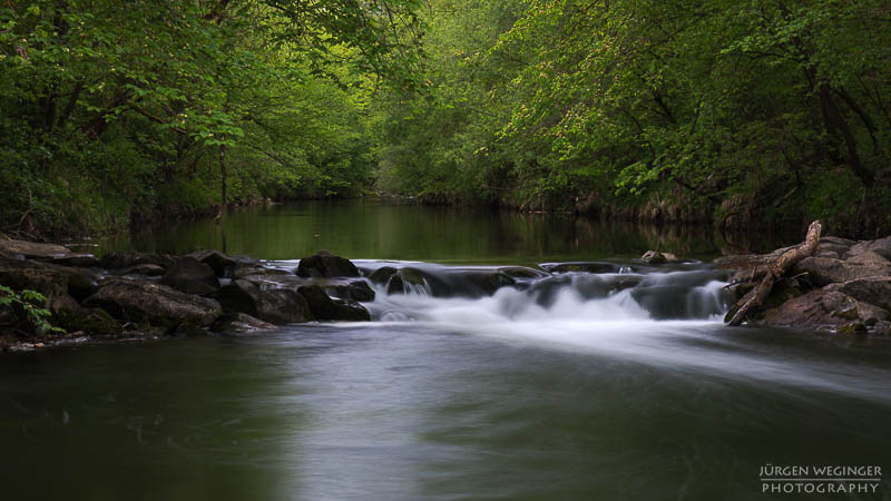 wasserfallfotografie, Langzeitbelichtung, Naturfotografie, Flusslandschaft, düstereslicht, Naturschönheit, dunklestimmung, wasserfallabenteuer, langzeitbelichtungskunst, flussidylle, wasserfallmagie, naturliebe, wasserfallerkundung, dramatischenatur