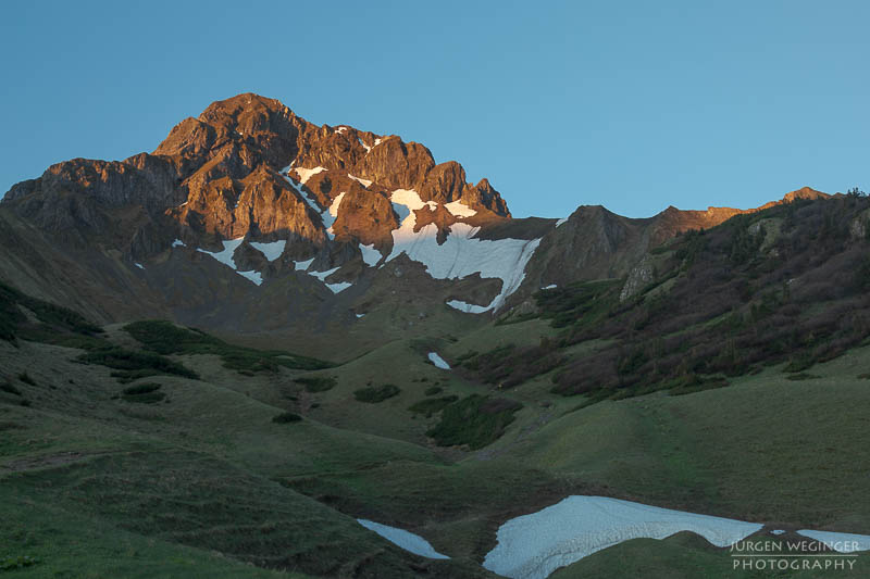 Sonnenaufgang im Gebirge mit Resten von Schneefeldern